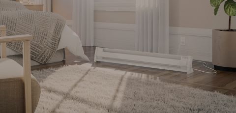 A living space with a Cadet Portable Baseboard heater plugged into the wall