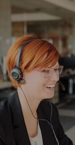 A support agent smiling while on a call 