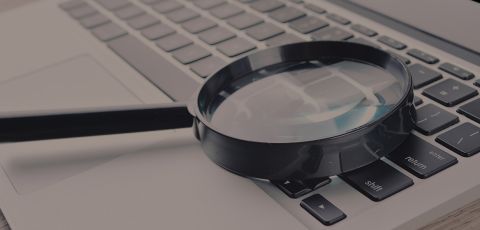 A magnifying glass on a computer keyboard