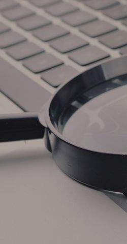 A magnifying glass on a computer keyboard