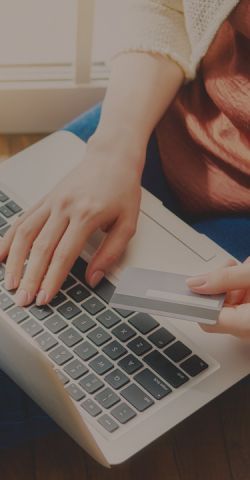 A person making a purchase using their laptop and credit card