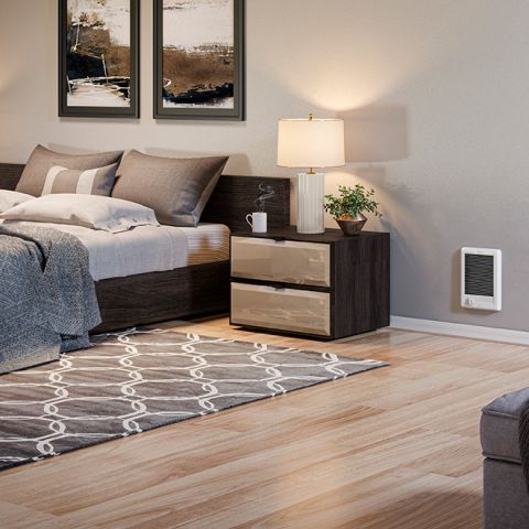 A bedroom with a wall heater mounted near the bottom of the wall