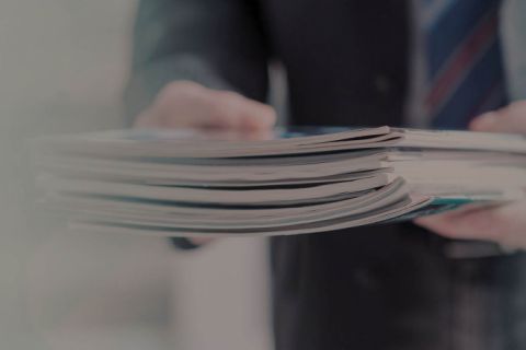 Person holding a pile of magazines